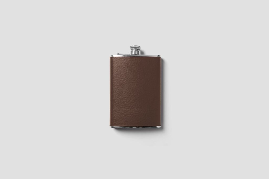 Sophisticated brown leather flask isolated against a white background