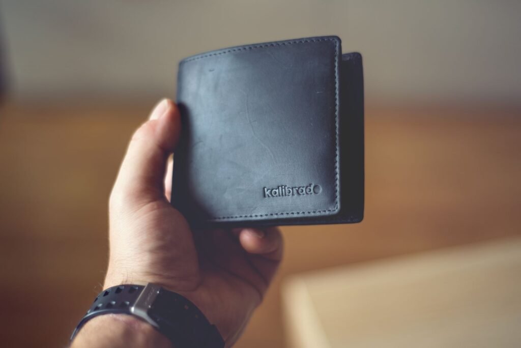 Close-up of a stylish black leather wallet held by a person