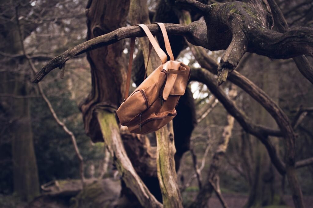 Tan leather backpack hanging on a twisted tree branch