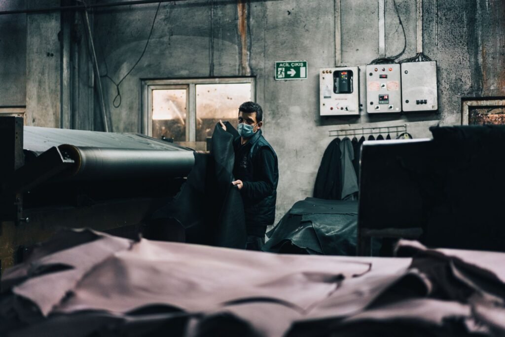 A worker in a tannery processes leather by hand