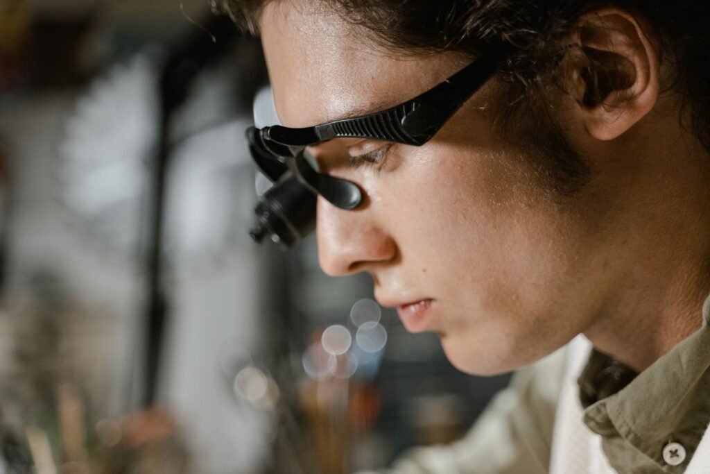 Close-up of a technician using a magnifying glass for precision inspection work