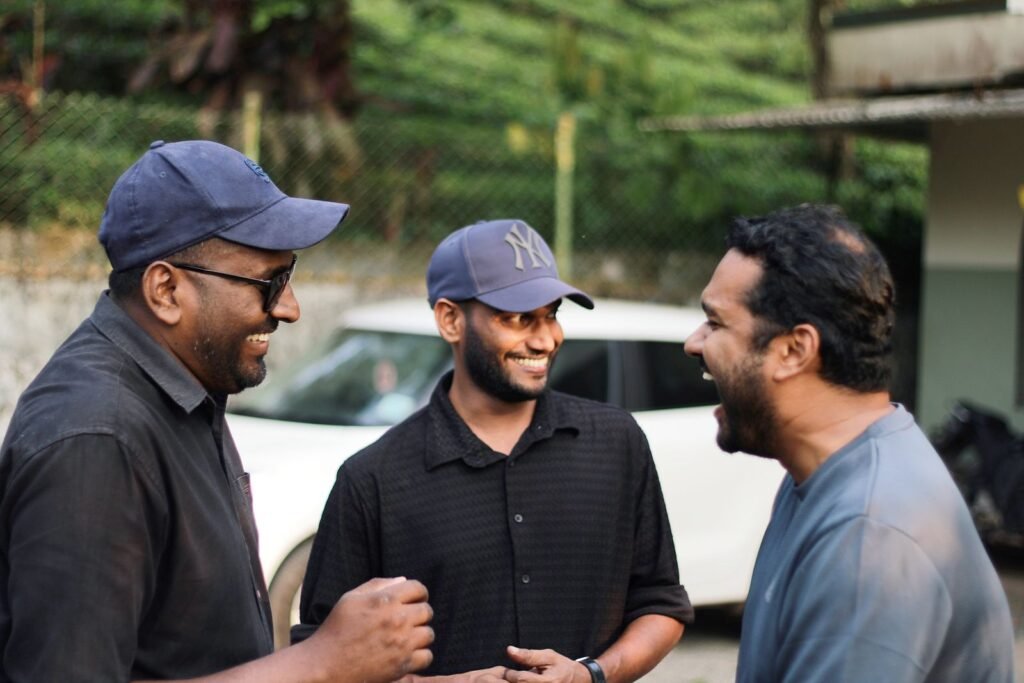 Three men enjoy a shared moment of laughter outdoors