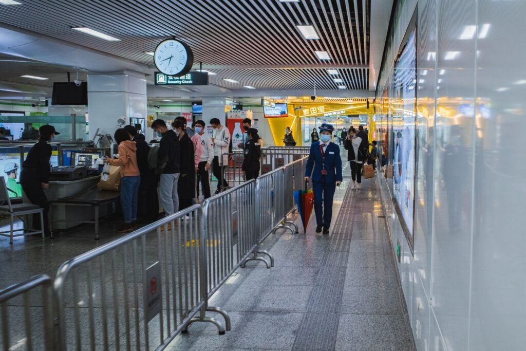 Travelers passing through airport security with staff present