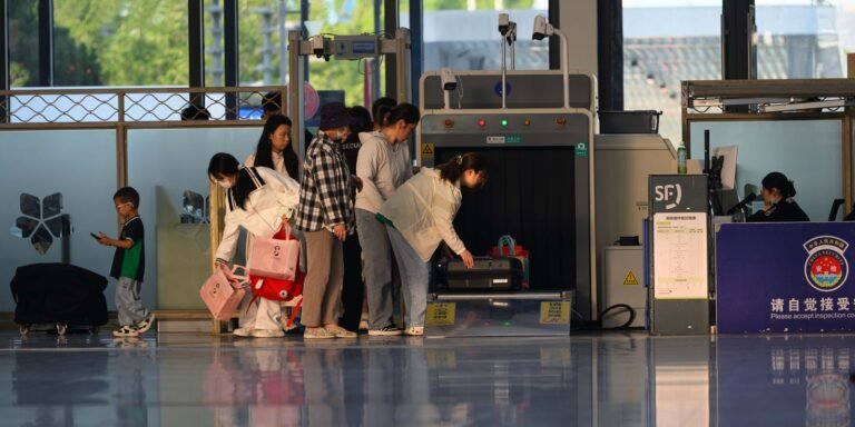 Travelers undergo security screening at an airport terminal