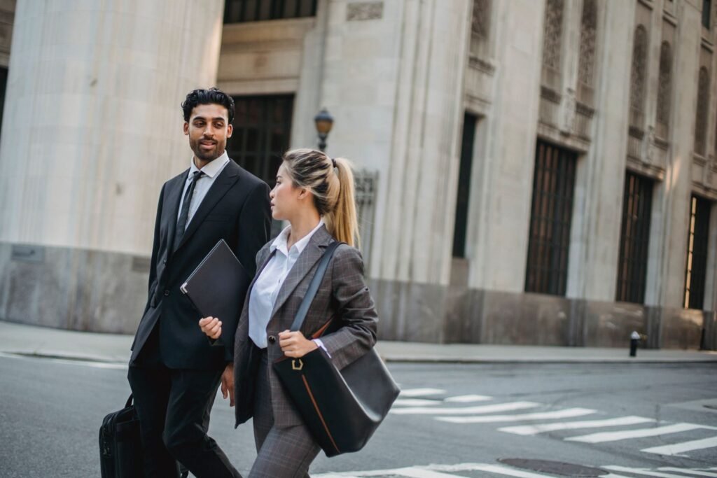 Two business professionals walking outdoors wearing suits