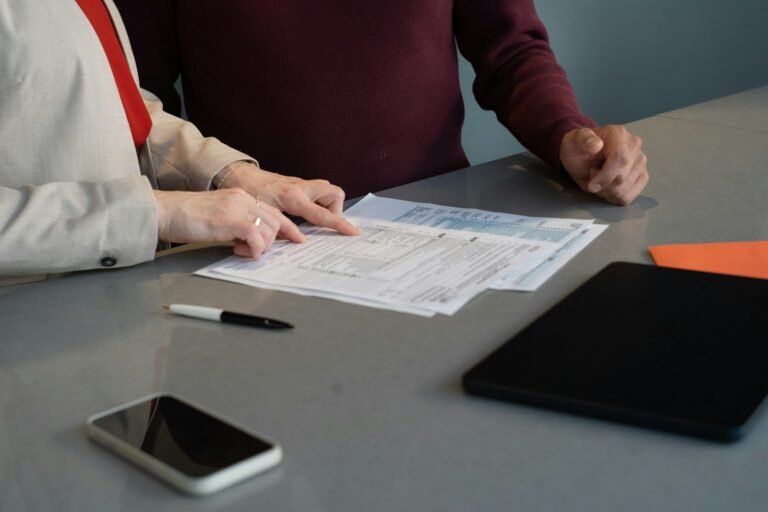 Two people reviewing paperwork and documents together at a table