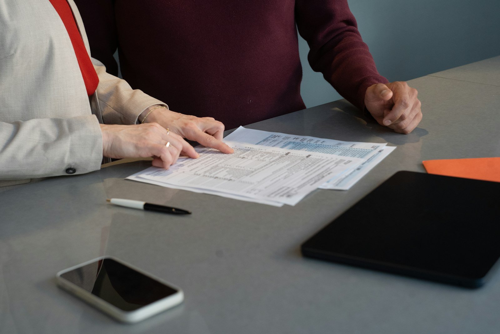 Two people reviewing paperwork and documents together at a table