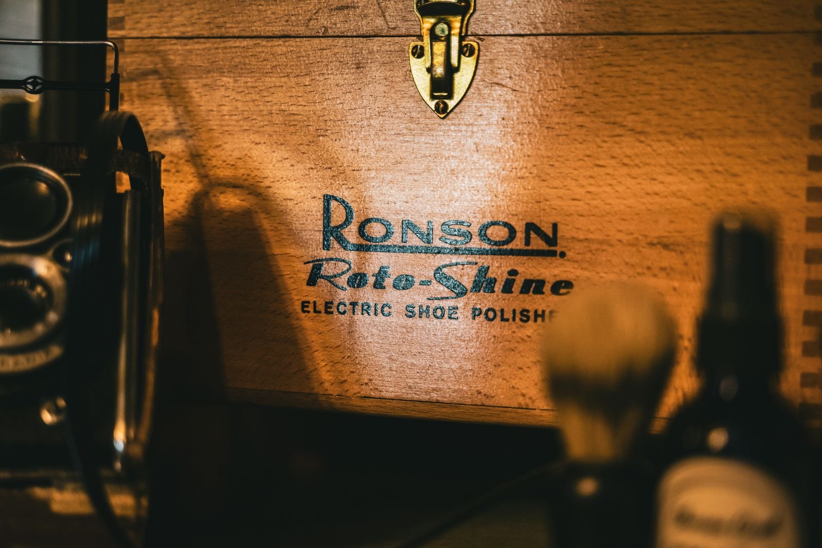 Close-up of a vintage wooden shoe polish box with detailed engraving