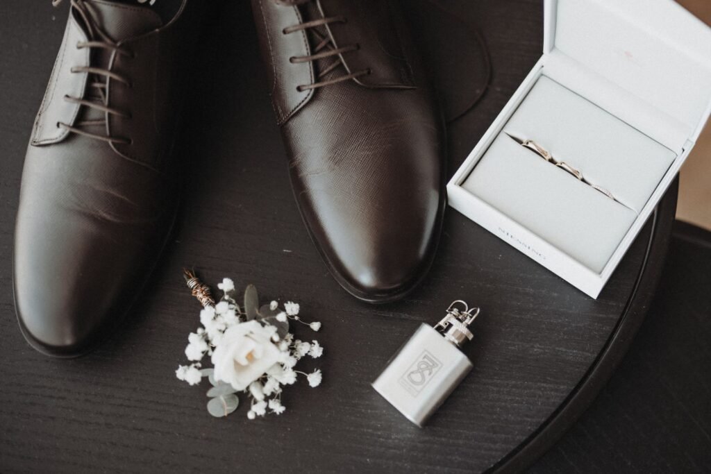 Stylish wedding accessories including shoes and a boutonniere