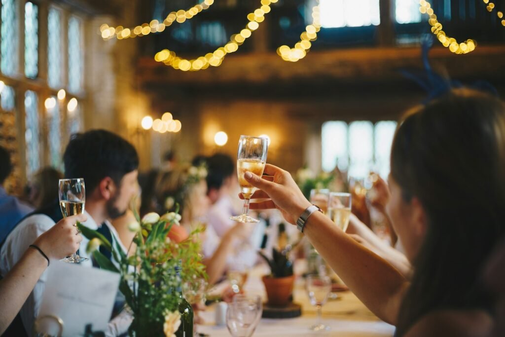 People raising wine glasses in a toast at a rehearsal dinner
