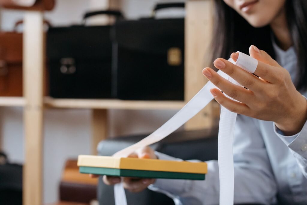 Close-up of a woman holding a gift box with ribbon in an office setting