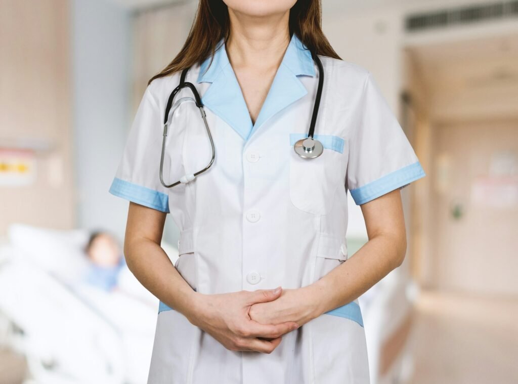 Woman in a white button-up shirt wearing a blue stethoscope