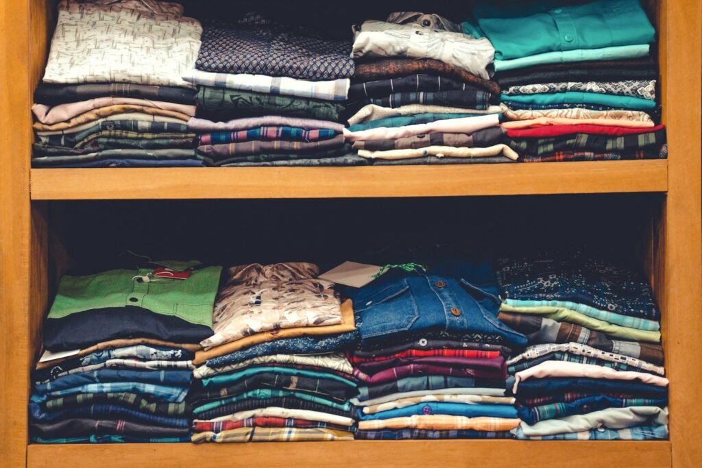 Wooden shelf filled with neatly folded shirts