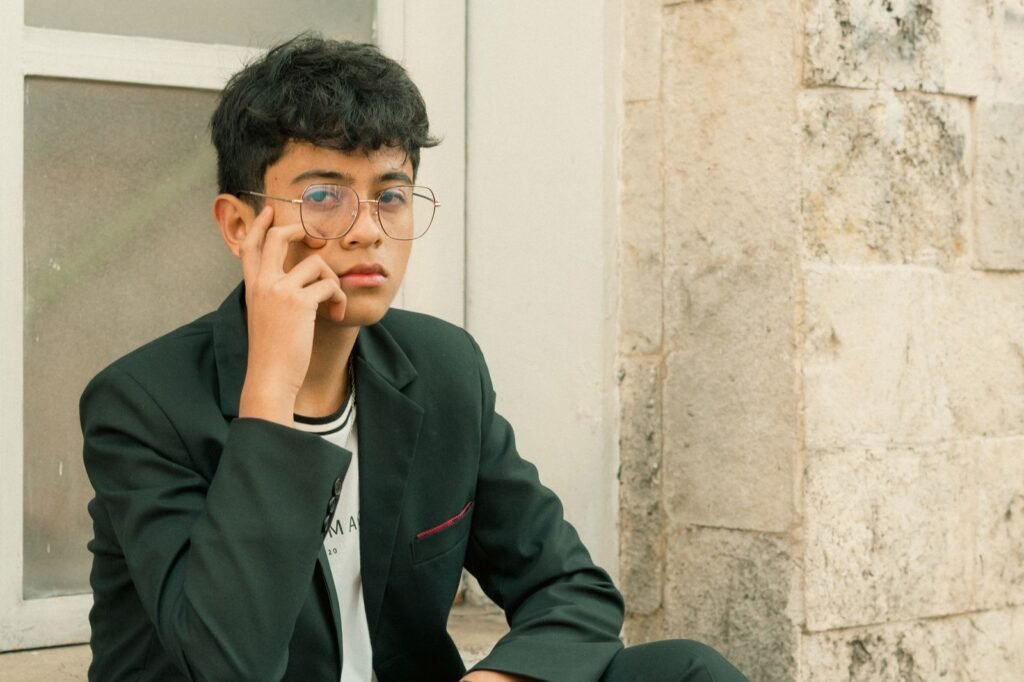 Young man in a suit with glasses exudes confidence while sitting