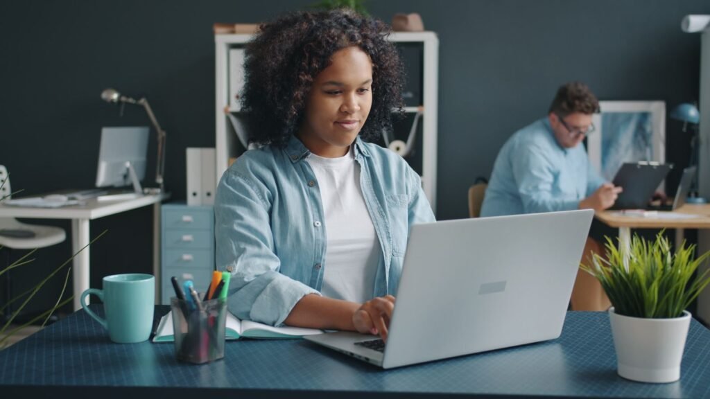 Young woman focused on her laptop in a contemporary office